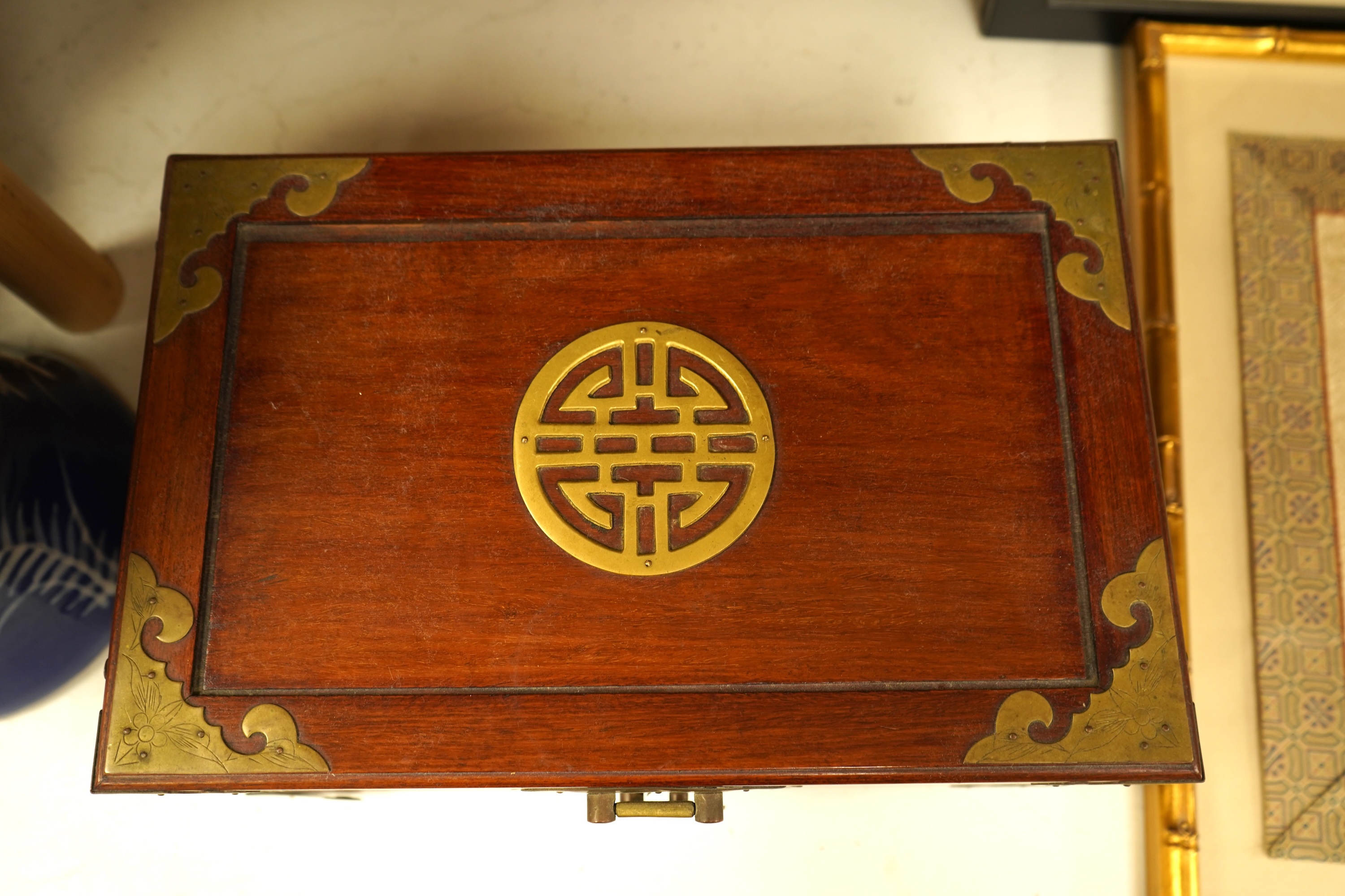 A Chinese brass bound rosewood jewellery box with twin handles, the interior with sewing accessories and threads, 35cm wide
